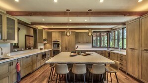 Una cocina amplia con una isla grande, armarios de madera y electrodomésticos modernos.