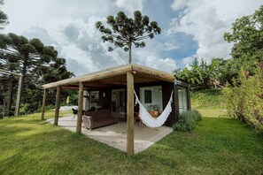 Une petite structure ouverte sur l’extérieur, dotée d ’un toit en bois et d’un hamac.
