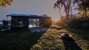 Una estructura moderna al aire libre con un área de estar cubierta y un pozo de fuego.