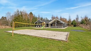 A playground with a volleyball net, a slide, and a swing set. - Gorgeous home in Glesborg with sauna (Glesborg)