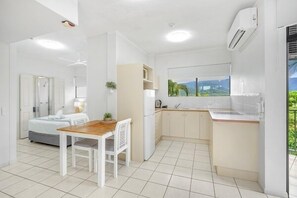 Cozy living space with a kitchenette, dining table, and sofa, offering a view of the outdoors.