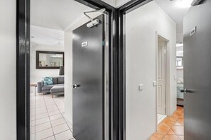 Contemporary living space with a hallway leading to a room with a door and a light fixture.