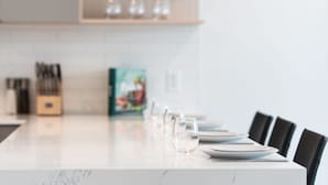 Uma mesa de jantar com cadeiras, facas e um livro de receitas.