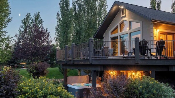 Une maison moderne dotée d’une terrasse, d’un jacuzzi et d’un jardin bien entretenu.