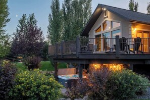 Une maison moderne dotée d’une terrasse, d’un jacuzzi et d’un jardin bien entretenu.