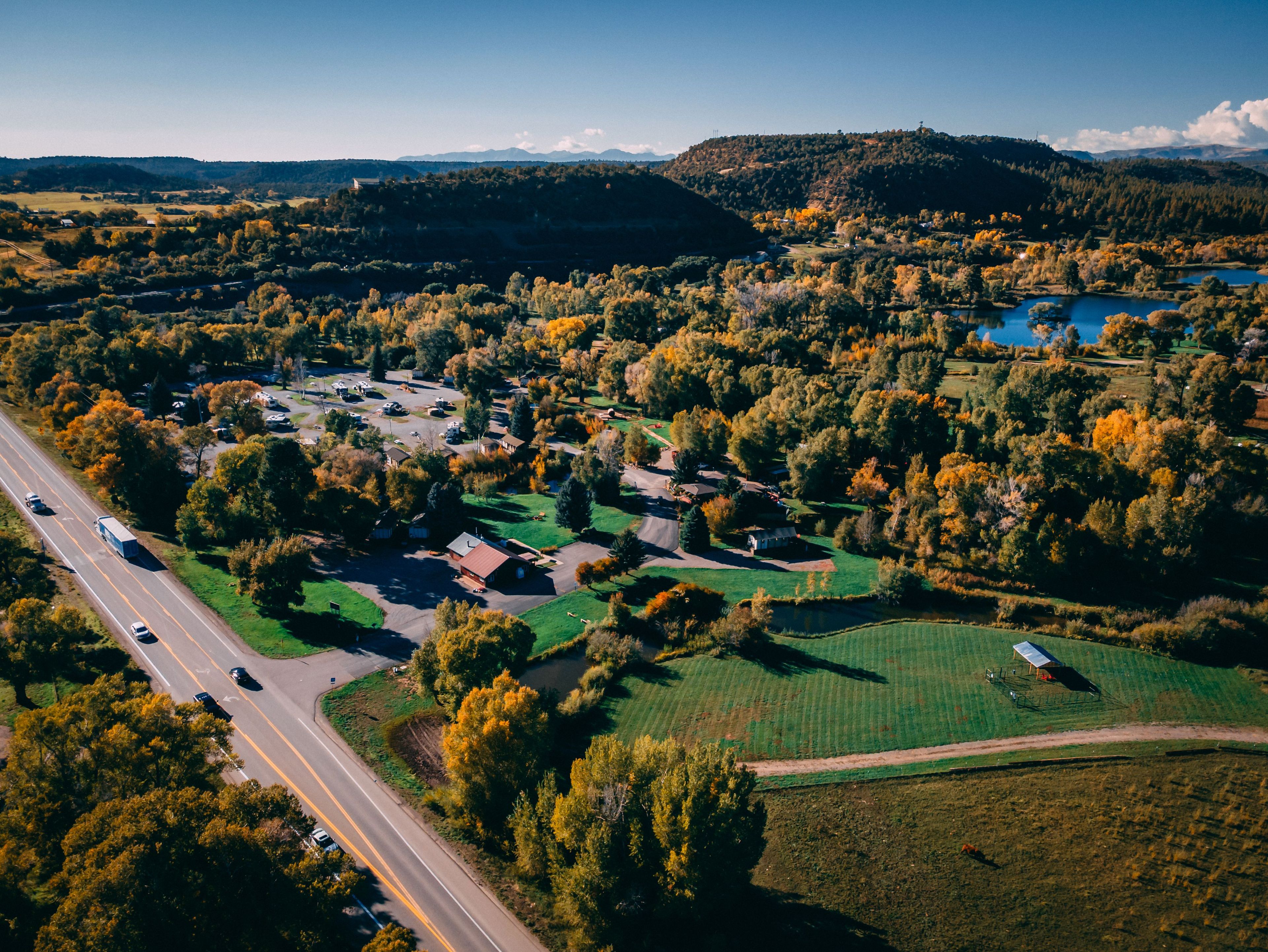 An aerial view of a residential area with houses, a road, and a body of water.