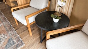 A modern living room with a round black table, two wooden armchairs, a small white side table with a potted plant, and a floor lamp. - Outdoorsy Bayfield (Bayfield)