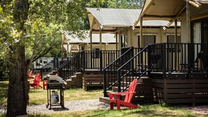 A campsite with wooden cabins, a covered deck, and a gravel path. - Outdoorsy Bayfield (Bayfield)