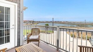 Ein Balkon mit Blick auf einen See und entfernte Gebäude.