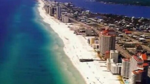 An aerial view of a coastal city with a long beach, high-rise buildings, and a clear blue sea. - Hidden in Paradise/ Pet friendly/ private house! (Gulf Shores)