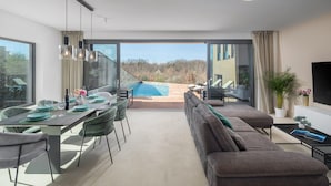A modern dining area with a view of a swimming pool and outdoor seating. - Nice home in Stancijeta (Stancijeta)