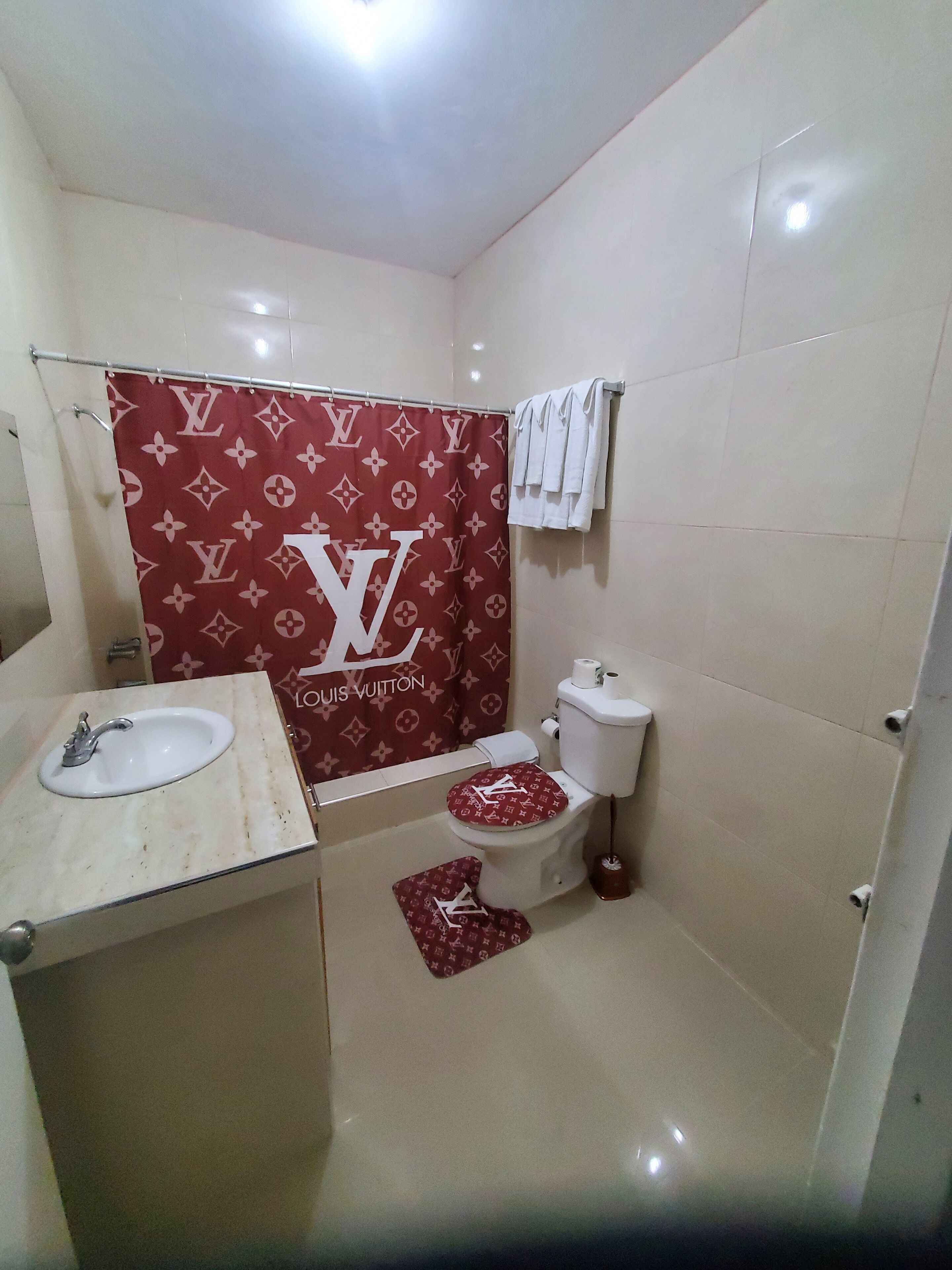 A bathroom with a toilet, sink, and shower curtain.