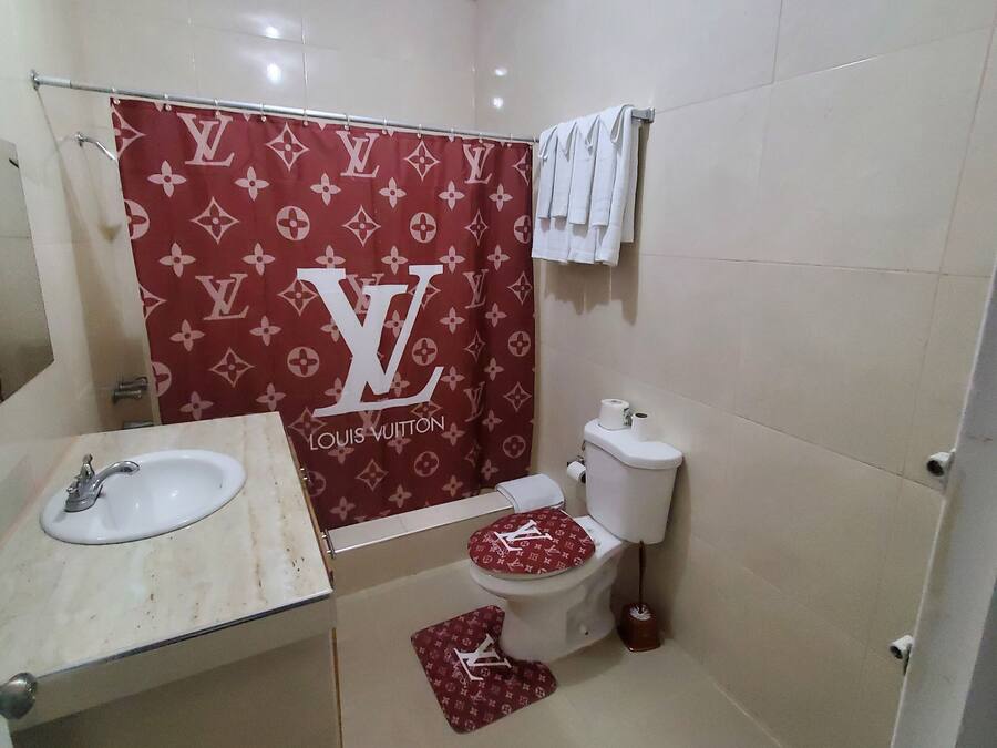 A bathroom with a toilet, sink, and shower curtain.