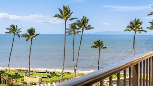 A balcony with a view of the ocean and palm trees. - SUGAR BEACH BLISS #2- BRAND NEW Designer Luxury-Ocean/Volcano Views 5 STAR Owner (Kihei)
