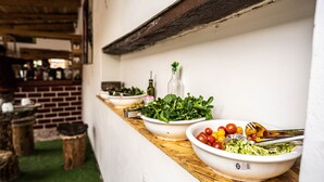 A row of white bowls on a wooden counter with various salads and vegetables. - MAMA GREEN Eco Lodge l Permaculture Farm l Farm To Table (Urubamba)