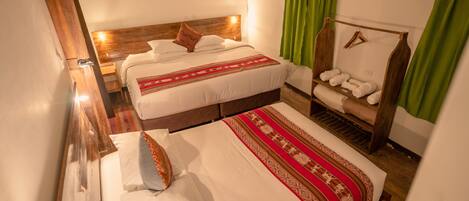 Habitación de hotel con dos camas, cabecero de madera, cortina verde y repisa con toallas.