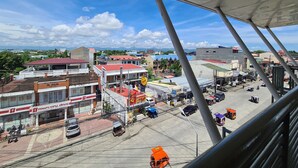 A view of a commercial area with buildings, shops, and vehicles. - Grace & RB Hotel (Kalibo)