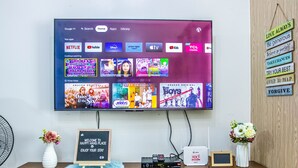A flat-screen TV mounted on a wall displaying various streaming apps. - Stylish 1BR Retreat at Trees Residences — Fast WiFi, Smart TV, Near SM Fairview (Quezon City)