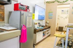 Keittiössä on jääkaappi, mikroaaltouuni, televisio ja pesuallas.