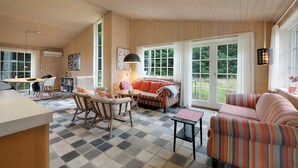 A cozy interior with a checkered floor, a sofa, a dining table, and a kitchen area. - Beautiful house, 1st row to the water (Fur)