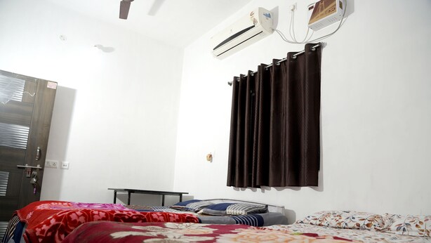 Une chambre équipée d’un lit, d’un bureau et d’un appareil de climatisation.
