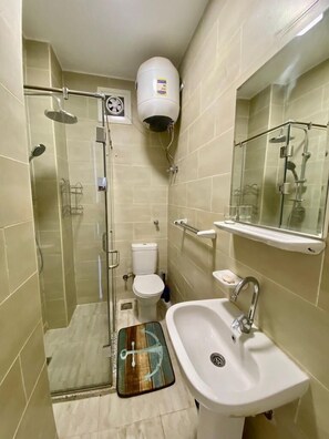 A bathroom with a glass shower enclosure, a toilet, a sink, and a mirror. - 1 Bed Apartment - Balcony, Pool, Parking (Hurghada)