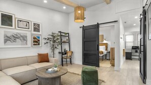 A modern living room with a sofa, coffee table, and artwork on the wall. - Private Luxury Tiny Home (Dearborn Heights)