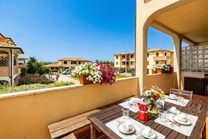 A dining table set outdoors with a view of other buildings.