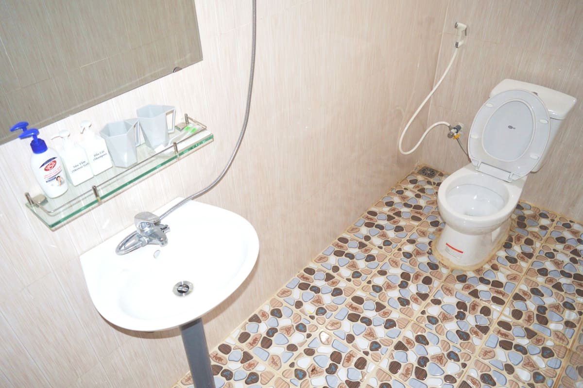 Een badkamer met een wit wastafel, toilet en douche.
