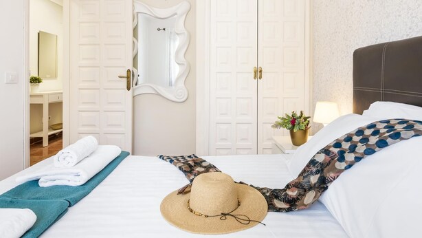 A hotel room with a bed, a mirror, a desk, and a nightstand with a lamp. - 9 Amarilla Bay Holiday Pool Terrace (Costa del Silencio)