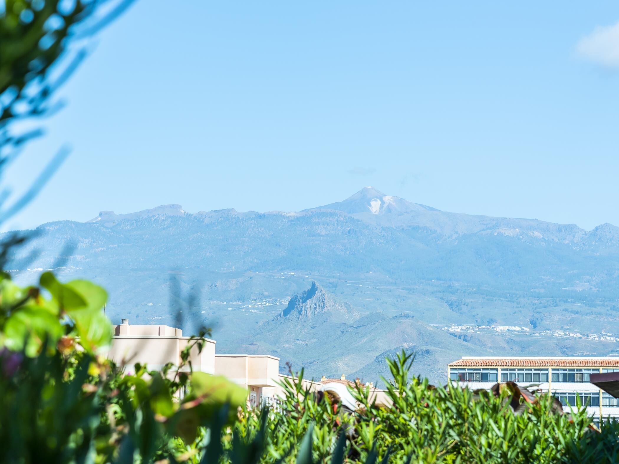 A mountain landscape with a building in the foreground.