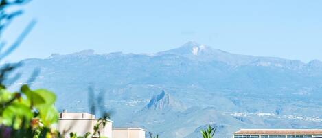 A mountain landscape with a building in the foreground.