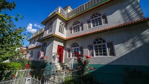 Un bâtiment à deux étages avec une porte rouge, de nombreuses fenêtres et un balcon.