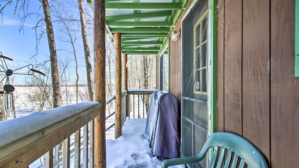 A wooden porch with a green roof, a bench, and a covered area. - Secluded Remer Cabin w/ Lake Access! (Remer)