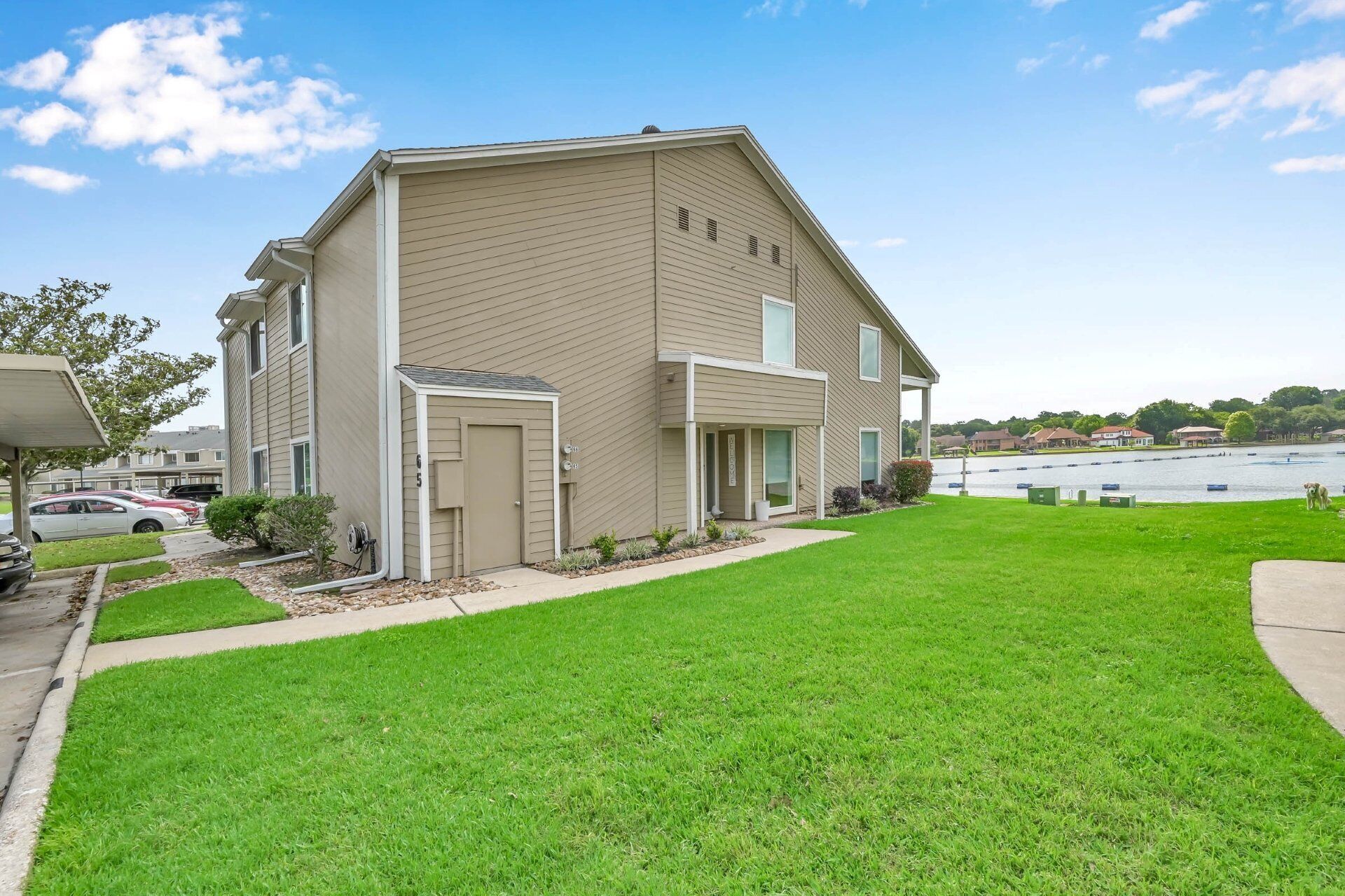 A two-story building with a flat roof, a covered porch, and a well-maintained lawn.