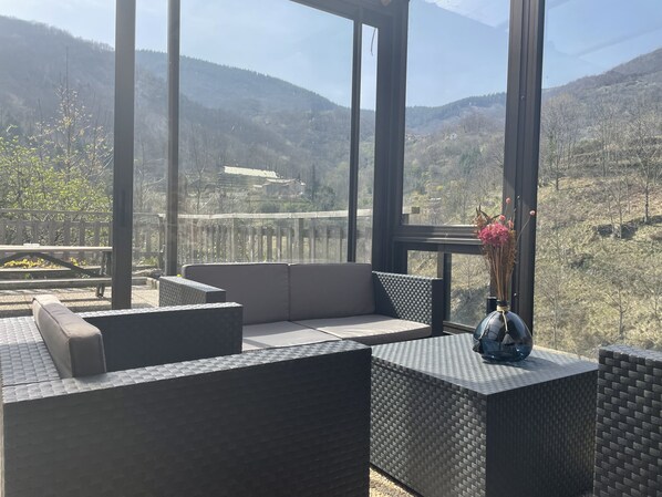 A modern outdoor seating area with a view of a mountainous landscape.