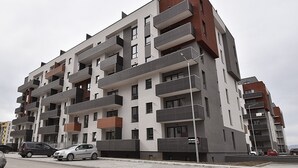A multi-story residential building with balconies, a parking area, and a street view. - Toia Studio (Brasov)