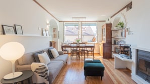 Ein gemütliches Wohnzimmer mit einer Couch, einem Esstisch und einem Kamin.