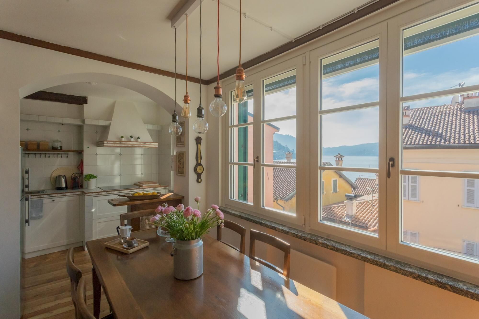 A kitchen with a dining area, large windows, and a view of the city.