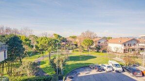 A residential area with a playground, parked cars, and houses.