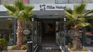 The entrance to Mills Hotel with a modern design, featuring glass doors and palm trees. - MILLS HOTEL (Tekirdag)