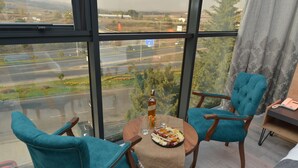 A balcony with a table set for two, chairs, a bottle, and a plate of food. - MILLS HOTEL (Tekirdag)