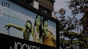 A building with multiple balconies and a large billboard advertising a brand. - Casa Mel (Puducherry)