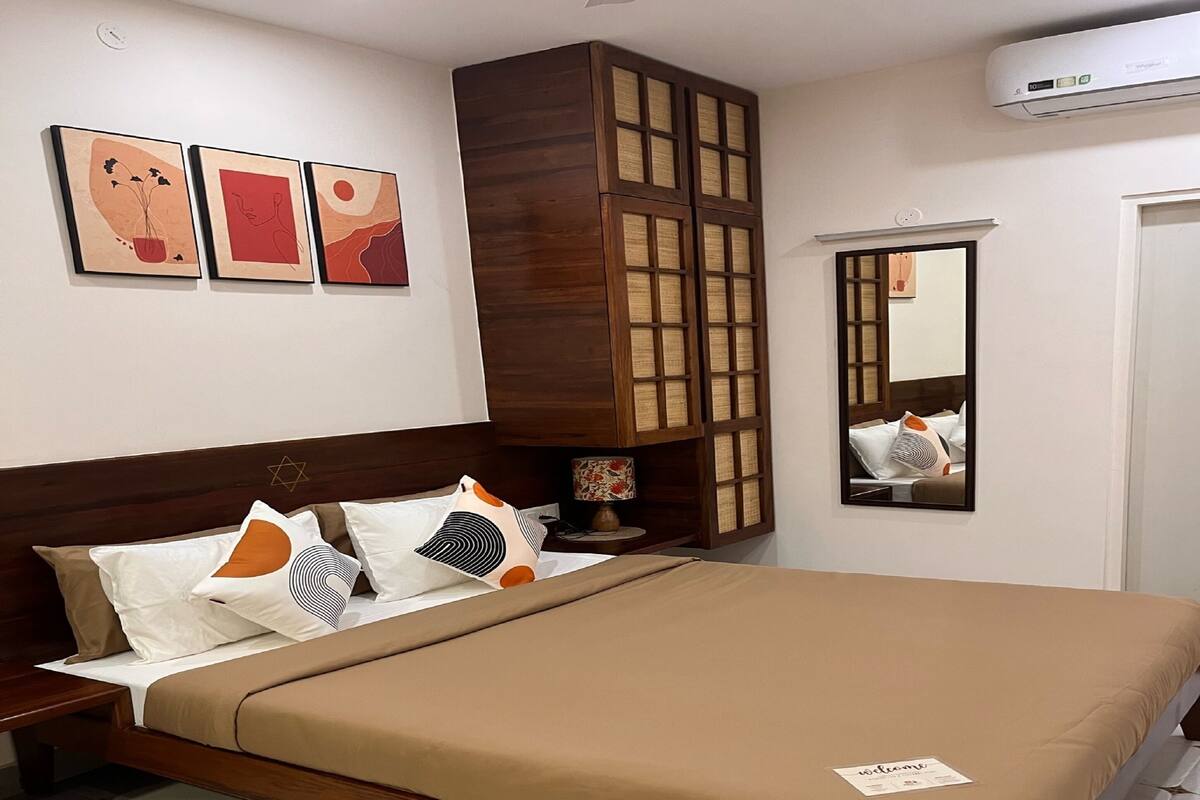 Un dormitorio con cama de madera, mesita de noche, espejo y decoración en la pared.