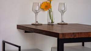 A table with two wine glasses and a vase with flowers. - Casa Mel (Puducherry)