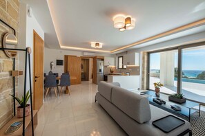 Una sala de estar moderna con sofá, comedor y cocina.