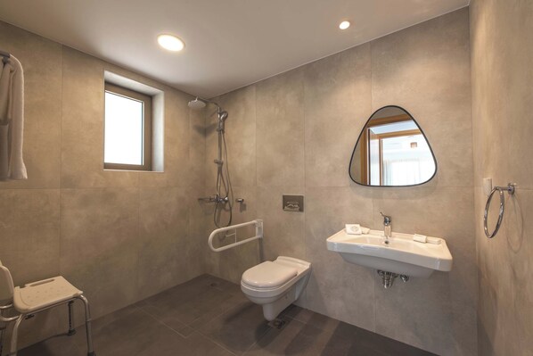 A modern bathroom with a shower, toilet, and sink.