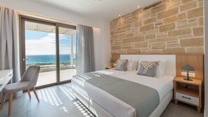 A bedroom with a large bed, a desk, and a chair. There is a view of the ocean through a sliding door. - Actea Seaview Villa 2 Free* heated pool & 800m sea (Kissamos)