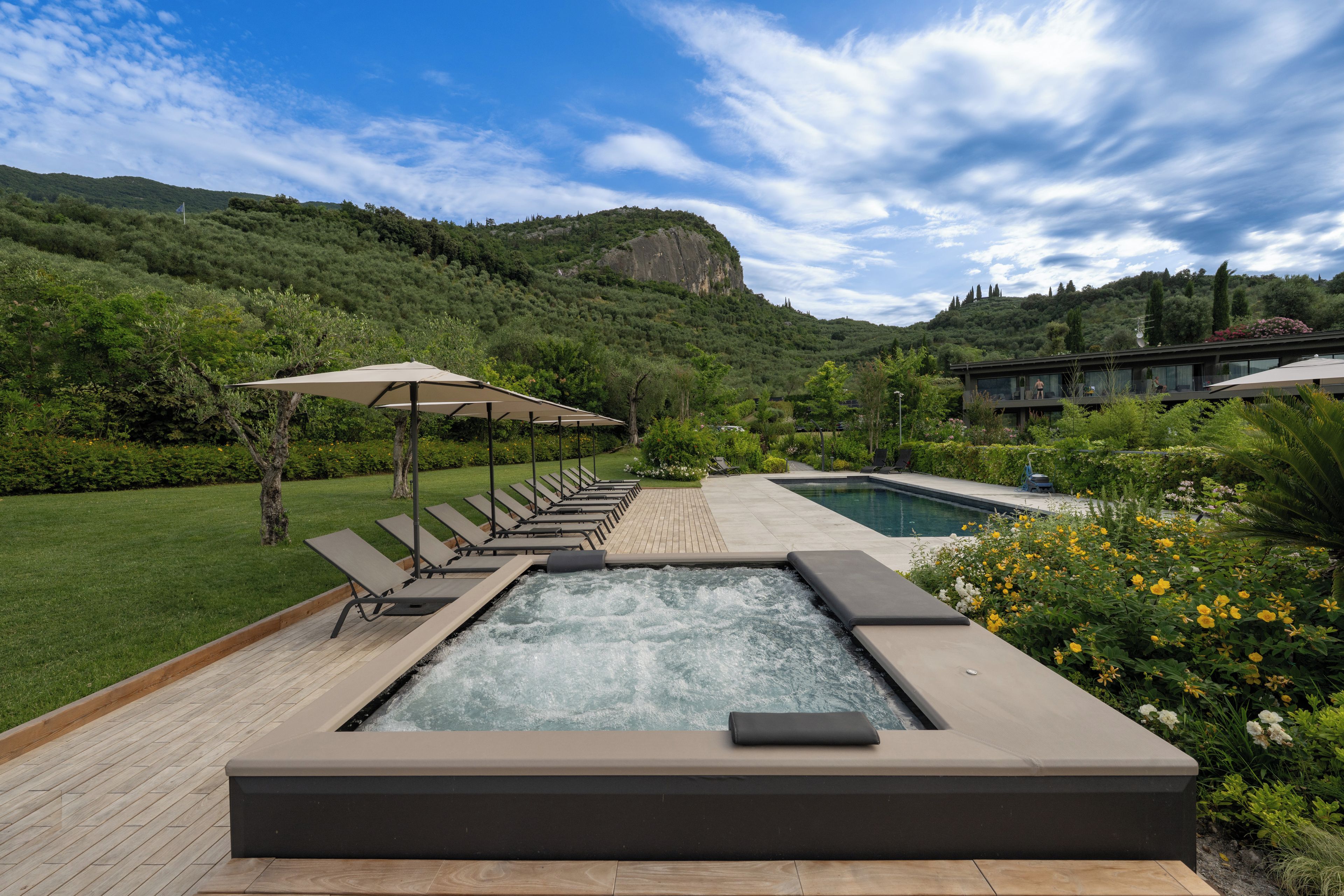 Ein Wellnessbereich mit Whirlpool, Liegestühlen und Schwimmbecken.