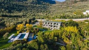 Un hôtel moderne doté d’une piscine, entouré d’une végétation luxuriante et de montagnes.
